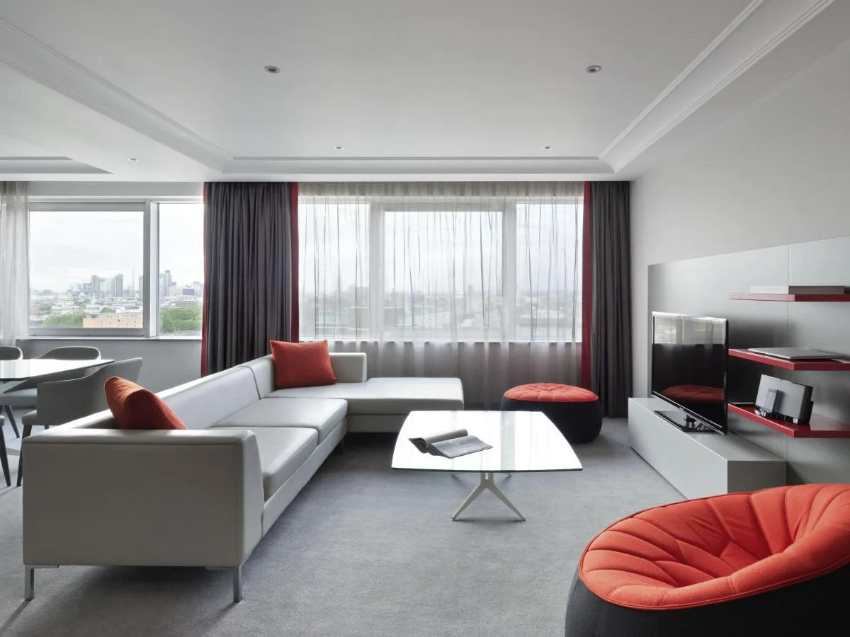 a living room with a white couch and a table at Pullman London St Pancras in London